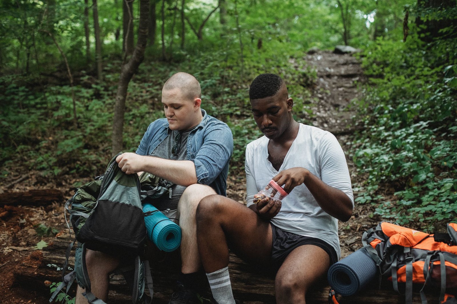 multiracial men eating snack during hiking
