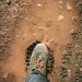 man wearing gray shoe standing on brown soil